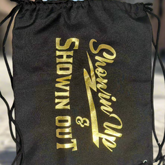 A black carrying bag with the text 'SHOWIN UP & SHOWIN OUT' printed in gold.