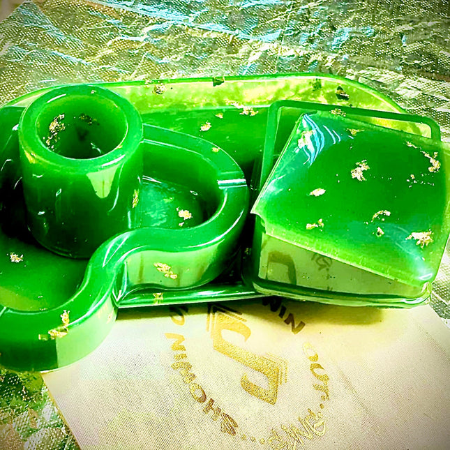 A green plastic tray adorned with a decorative gold leaf pattern, highlighting its stylish and vibrant appearance.