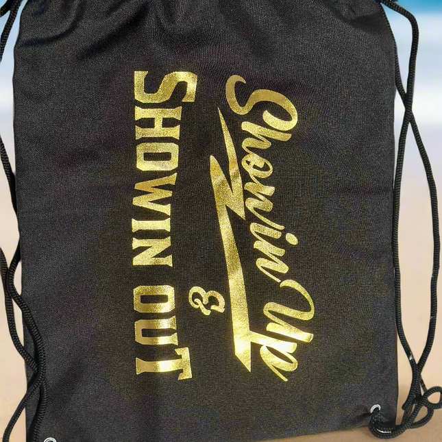 A black carrying bag with the text 'SHOWIN UP & SHOWIN OUT' printed in gold.