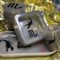 Customized grey trey set with a canister and ashtray featuring black scorpio designs on them, displayed on a yellow surface.